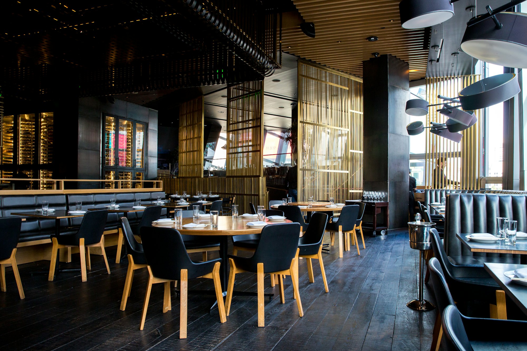Salle du bistrot La Table d'Olivia, tables en bois et lumière chaude