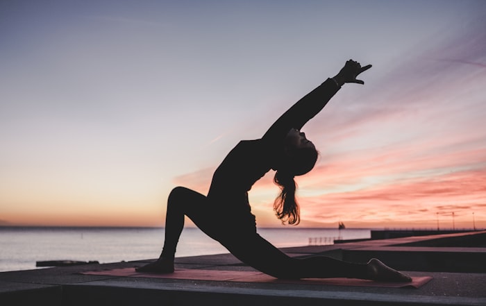 Silhouette en posture de yoga au coucher du soleil