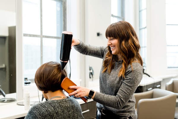 Coiffeuse au travail avec une cliente